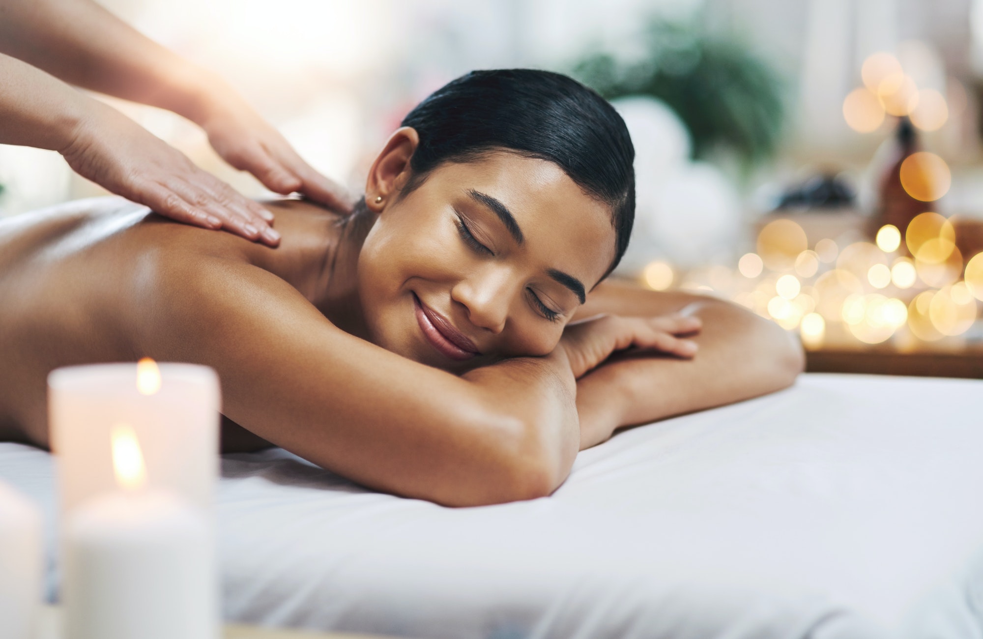 Shot of a relaxed an cheerful young woman getting a massage indoors at a spa
